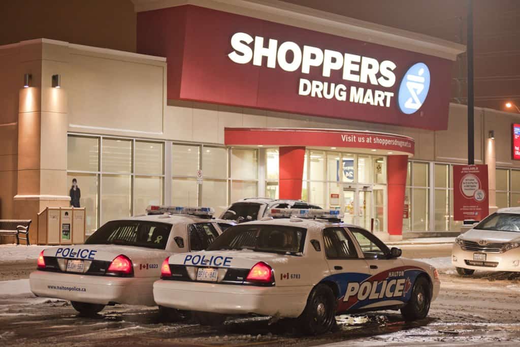 A couple of police cars parked in front of a store.