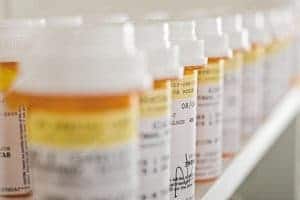 A row of medicine bottles sitting on top of a shelf.