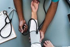 A person is taking blood pressure from another person.