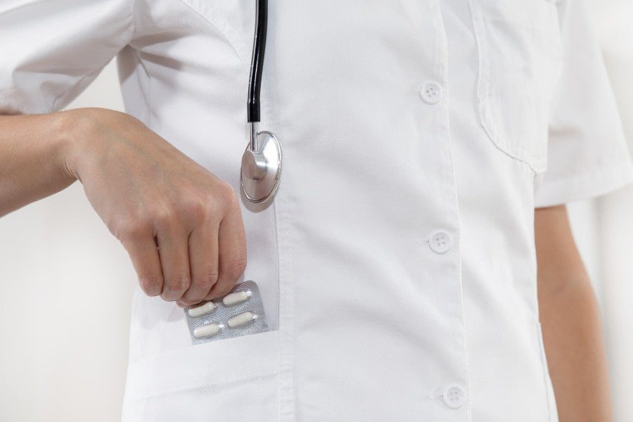 A doctor holding a metal object in his hand.