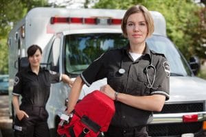 A woman in uniform holding a red backpack.