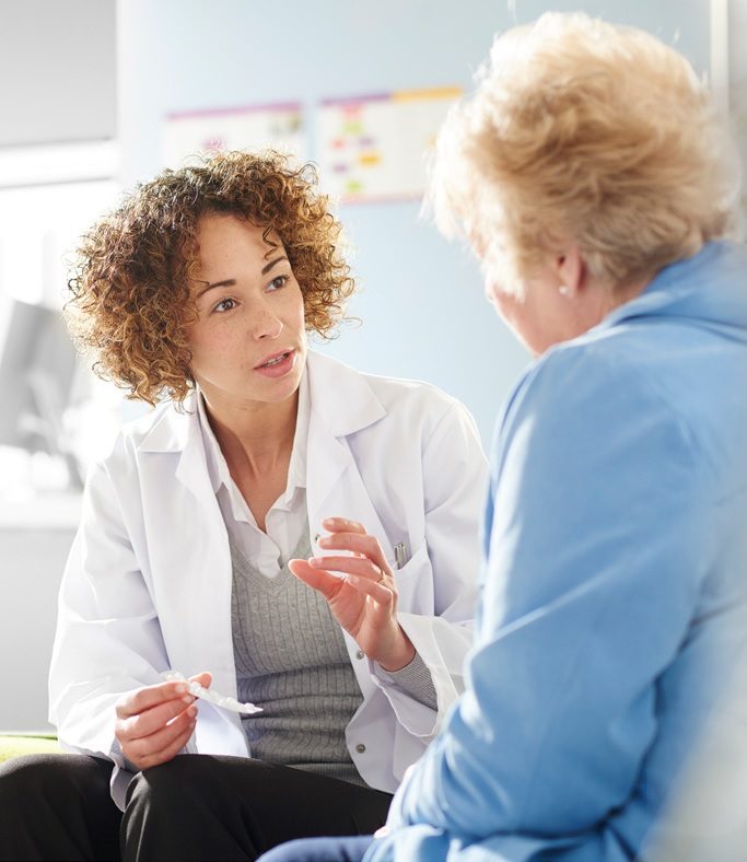 A woman talking to another person in a room.