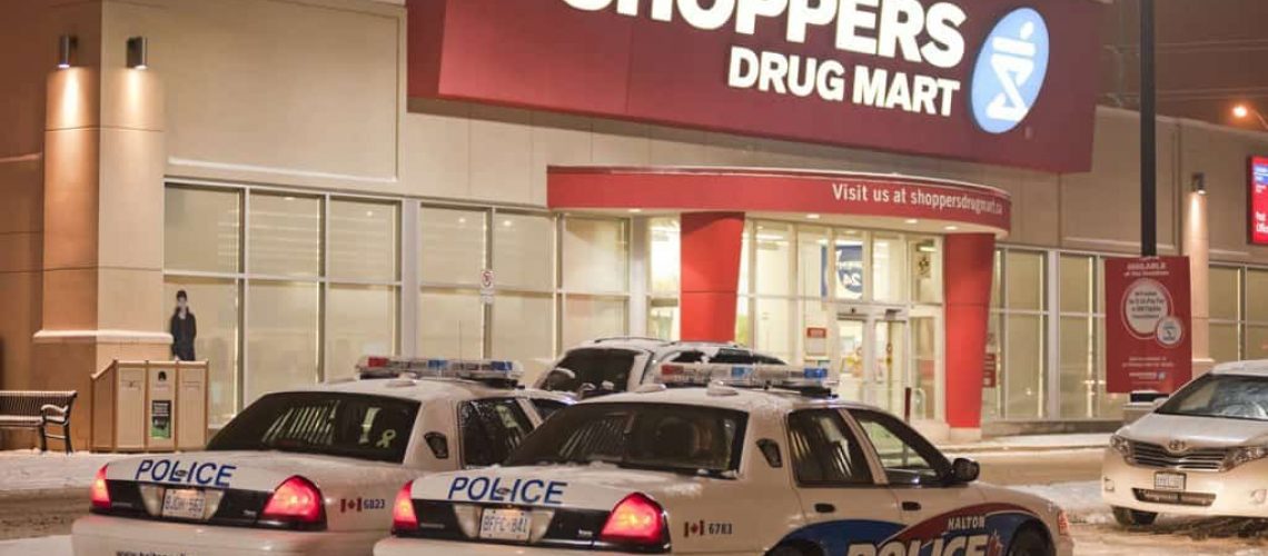 A couple of police cars parked in front of a store.